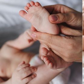 Les pieds d'un nourrisson tenus délicatement entre les mains d'une praticienne, lors d'une séance de réflexologie plantaire.
