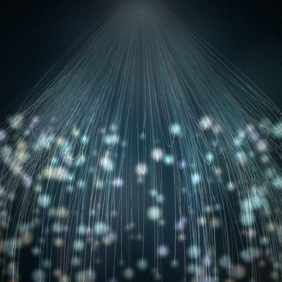 Rideau de fibres optiques lumineuses retombant en cascade dans une pi&egrave;ce sombre, aux teintes turquoise, dor&eacute;es et ros&eacute;es, comme dans un espace Snoezelen.